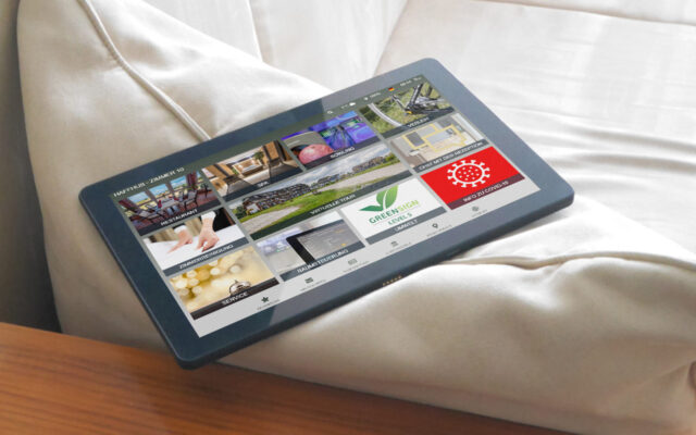 Tablet mit digitaler Gästemappe better.guest liegt auf Couch im Hotelzimmer