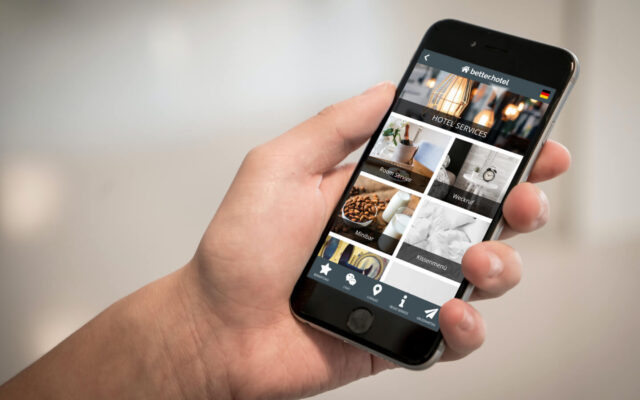 Hand hält Smartphone worauf digitale Gästemappe better.guest als App abgebildet ist