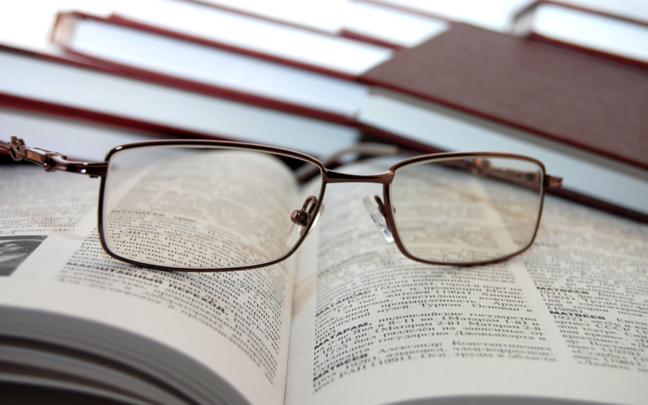 Abgesetzte Brille liegt auf einem Buch