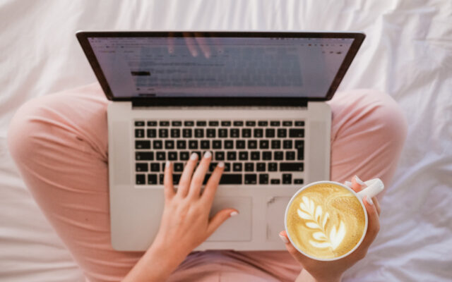 frau mit laptop auf dem schoß schaut onlinekurs