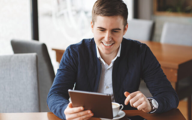 Mann hält Tablet in der Hand