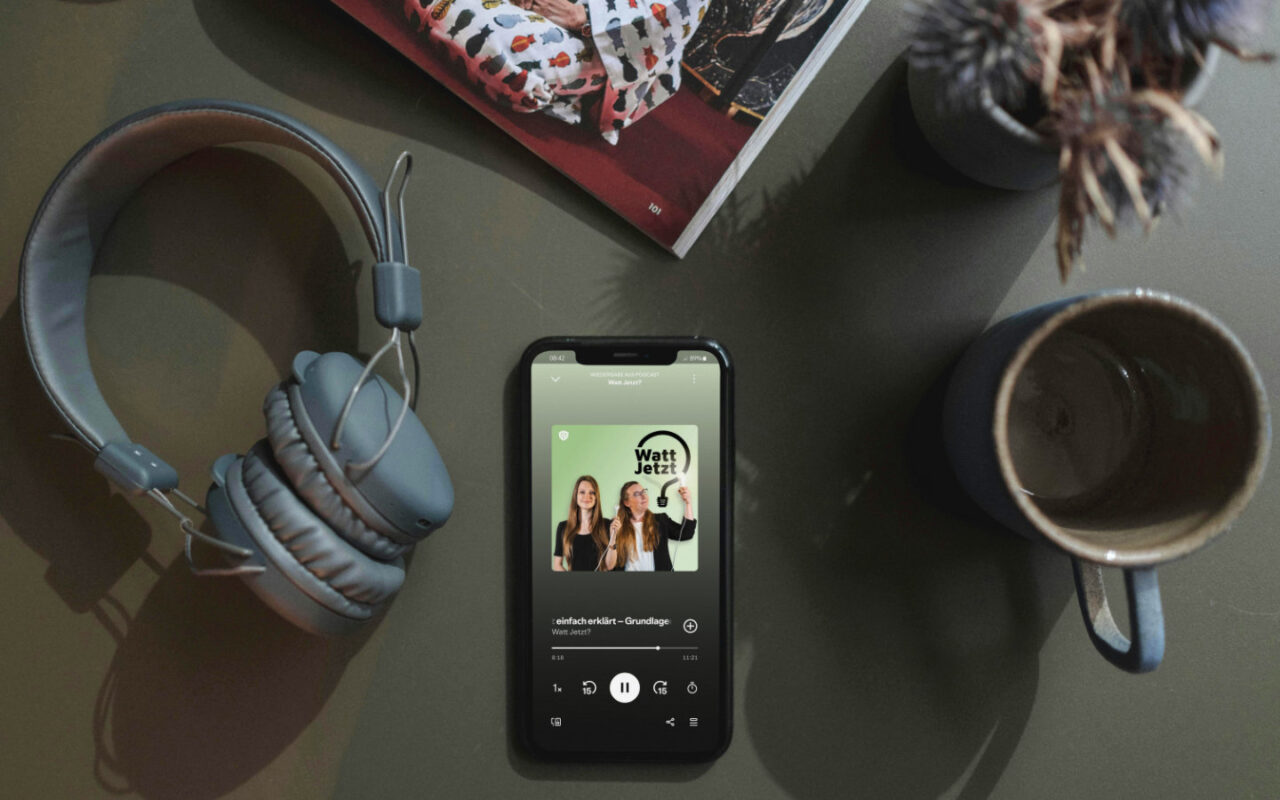smartphone liegt auf einem tisch und darauf läuft der podcast watt jetzt von betterspace